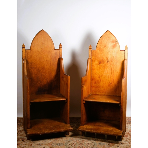 75 - A PAIR OF VINTAGE PINE THRONE CHAIRS each with a rectangular arched back above a panelled seat and a... 