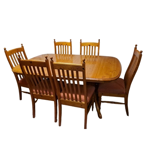 752 - AN EIGHT PIECE PINE BREAKFAST SUITE comprising six dining chairs each with vertical splats and uphol... 