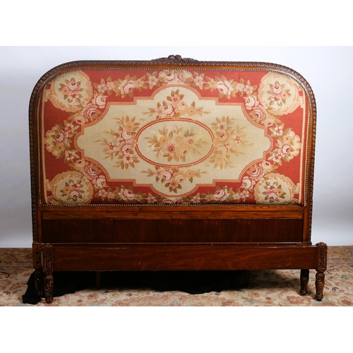 761 - A CONTINENTAL CARVED MAHOGANY BED the rectangular arched headboard with foliate cresting above a nee... 