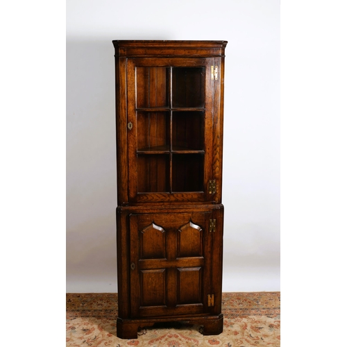 762 - A GOTHIC DESIGN OAK CORNER CABINET the moulded cornice above an astragal glazed door the base with a... 