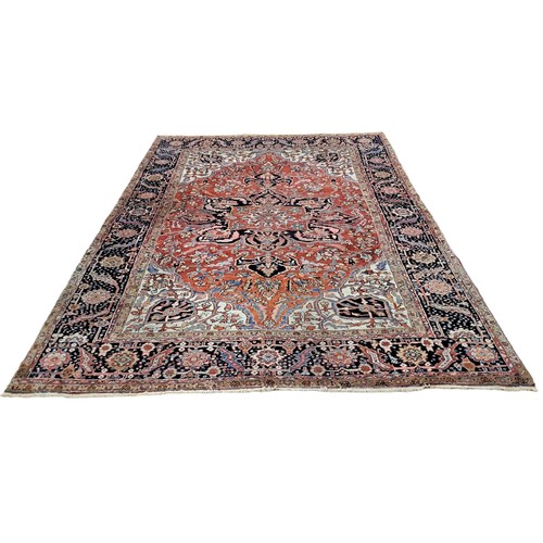 572 - A HERIZ WOOL RUG the multicoloured ground with central stylised flowerhead and foliate panel within ... 