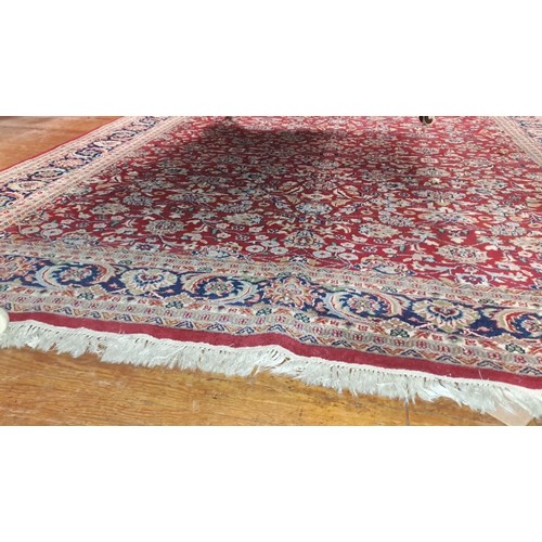 577 - A KESHAN WOOL RUG the wine ground with central floral panel within a conforming border 
315cm (l) x ... 