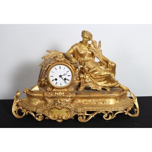 273 - A 19TH CENTURY GILT METAL MANTEL CLOCK of agricultural form with seated maiden holding sheath of cor... 