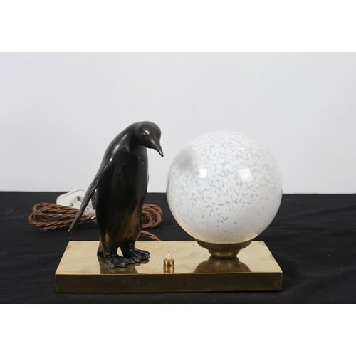 102 - AN ART DECO BRONZE AND BRASS NIGHT LIGHT with opaline glass shade flanked by a penguin shown standin... 