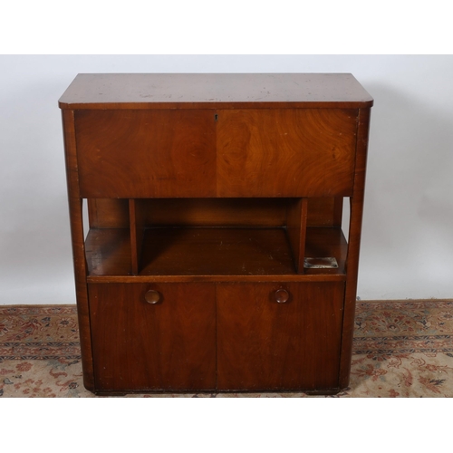 179 - A VINTAGE WALNUT SIDE CABINET of rectangular outline the shaped top above a hinged compartment conta... 