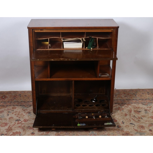 179 - A VINTAGE WALNUT SIDE CABINET of rectangular outline the shaped top above a hinged compartment conta... 