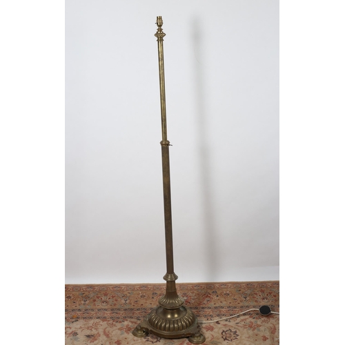 194 - A 19TH CENTURY BRASS TELESCOPIC STANDARD LAMP with reeded column above a lobed spreading foot on pad... 