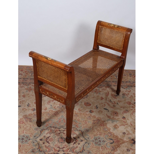 202 - A MAHOGANY AND POLYCHROME DUET STOOL of rectangular outline with caned panel ends with loose cushion... 