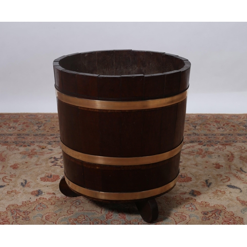 217 - A VINTAGE MAHOGANY AND BRASS BOUND BARREL of cylindrical tapering form on moulded legs 
48cm (h) x 4... 