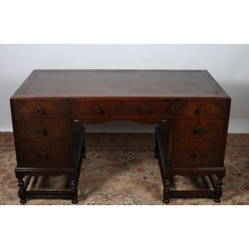 219 - A VINTAGE OAK DESK of rectangular outline the shaped top with Rexine writing surface above three fri... 