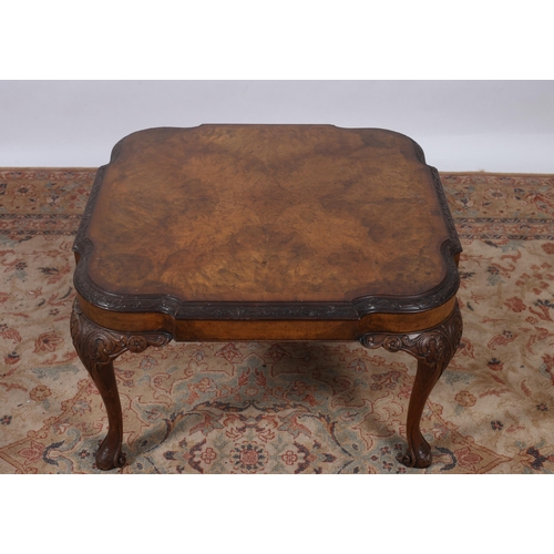 240 - A VINTAGE CARVED WALNUT CROSSBANDED COFFEE TABLE of rectangular shaped form with carved rim raised o... 