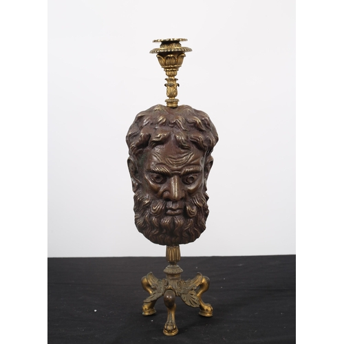 261 - A BRONZE AND BRASS CANDLESTICK in the form of a mask raised on a triform base with claw feet 
42cm (... 