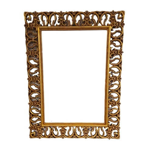 301 - A CONTINENTAL GILT FRAME MIRROR the rectangular bevelled glass plate within a pierced C-scroll and f... 