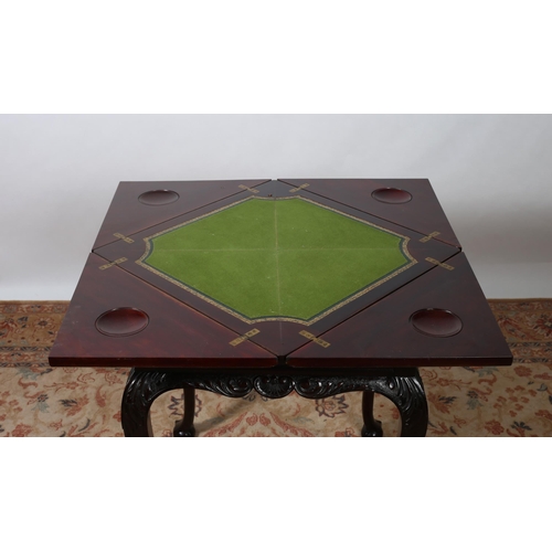 327 - AN EDWARDIAN CARVED MAHOGANY ENVELOPE CARD TABLE the square moulded top with hinged leaves with baiz... 