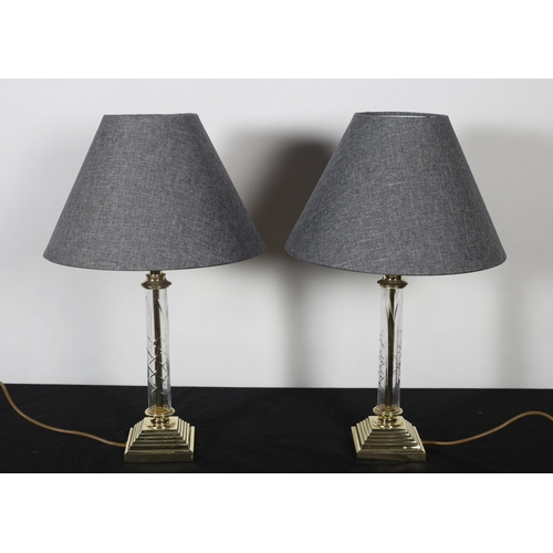 353 - A PAIR OF GILT BRASS AND GLAZED TABLE LAMPS each with a cylindrical column above a square stepped ba... 