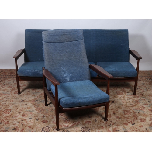 398 - A TWO PIECE VINTAGE TEAK AND UPHOLSTERED SUITE comprising a three seater settee the upholstered back... 