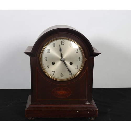 411 - A VINTAGE MAHOGANY INLAID MANTEL CLOCK of rectangular arched form with silvered dial on platform bas... 