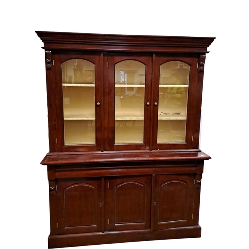 437 - A VICTORIAN STYLE MAHOGANY CHINA DISPLAY CABINET the moulded cornice above three glazed doors contai... 