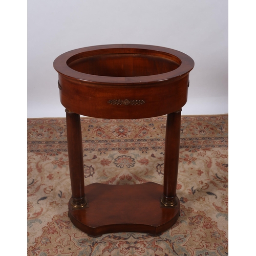 447 - AN EMPIRE DESIGN MAHOGANY JARDINIERE STAND of oval outline the shaped top above a moulded apron on d... 