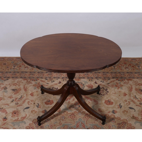 453 - A REGENCY DESIGN MAHOGANY WINE TABLE of oval outline the shaped top with reeded rim above a baluster... 