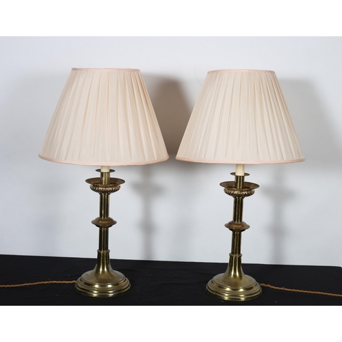 477 - A PAIR OF GOTHIC DESIGN BRASS TABLE LAMPS each with a knopped column raised on a circular spreading ... 