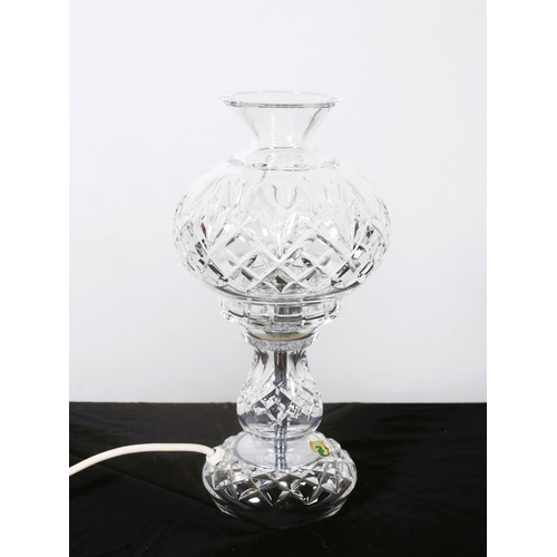 571 - A WATERFORD CUT GLASS TABLE LAMP the globe shade above a baluster column on a circular spreading foo... 