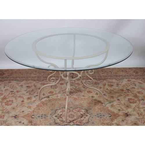 77 - A WROUGHT IRON AND GLAZED TABLE the circular bevelled glass top raised on a C-scroll base with pad f... 