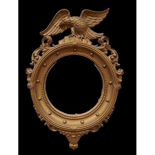 829 - A GILT FRAME CONVEX MIRROR with ball and beadwork decoration surmounted by a winged eagle 
53cm (h) ... 