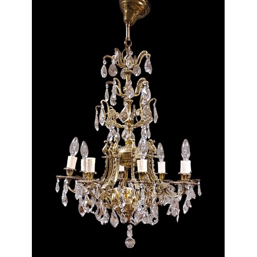 392 - A CONTINENTAL GILT BRASS AND CUT GLASS EIGHT BRANCH CHANDELIER with foliate cast scroll arms and dri... 