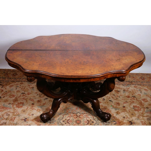 101 - A 19TH CENTURY BURR WALNUT CENTRE TABLE of serpentine outline the shaped top on quadruped carved scr... 