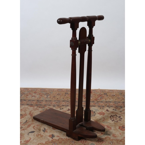 492 - A 19TH CENTURY MAHOGANY AND BRASS BOUND BOOT PULL with baluster handles raised on cylindrical ring t... 