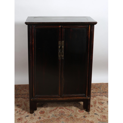 112 - A CHINESE BLACK LACQUERED SIDE CABINET of rectangular outline the shaped top above a pair of panel d... 