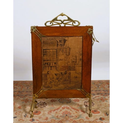 142 - AN ART DECO OAK AND BRASS MOUNTED FIRESCREEN of rectangular form with needlework panel on splayed le... 