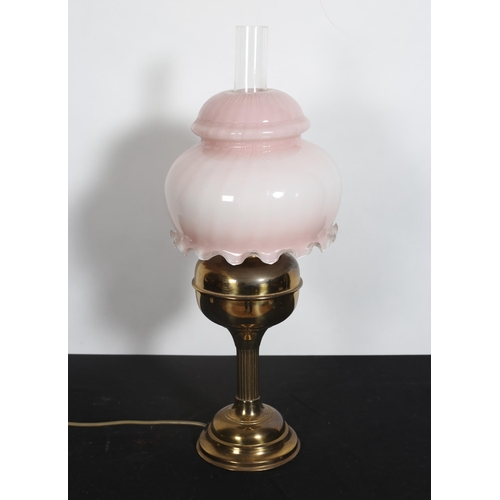 183 - A BRASS TABLE LAMP the opaline and light pink shade above a bulbous reeded column on a circular spre... 