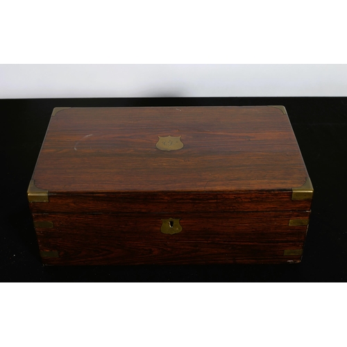 185 - A 19TH CENTURY ROSEWOOD AND BRASS BOUND STATIONERY BOX the rectangular hinged lid containing a toole... 