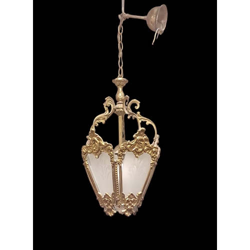 193 - A GILT BRASS AND FROSTED GLASS SINGLE LIGHT LANTERN the foliate cast frame with frosted glass panels... 