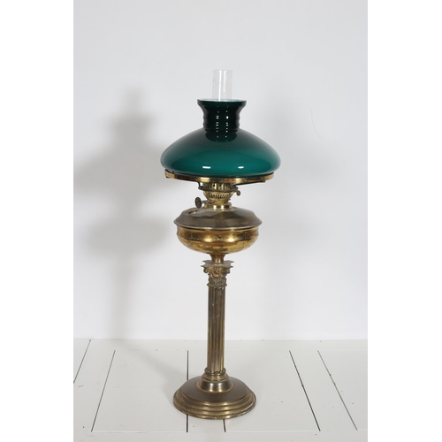 205 - A VINTAGE BRASS OIL LAMP the Corinthian column raised on a circular spreading foot with a glazed sha... 