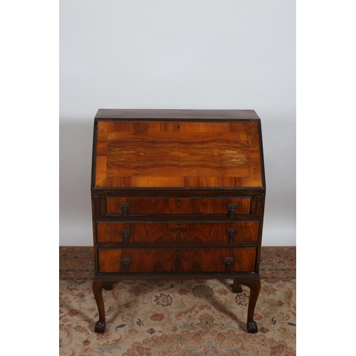 207 - A VINTAGE WALNUT BUREAU the hinged writing slope containing pigeon holes and drawers above three lon... 