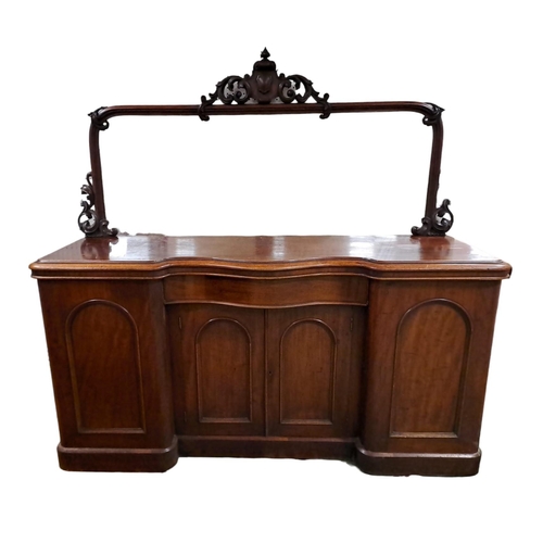 218 - A 19TH CENTURY MAHOGANY SIDEBOARD of serpentine outline the plate glass mirror within a pierced C-sc... 