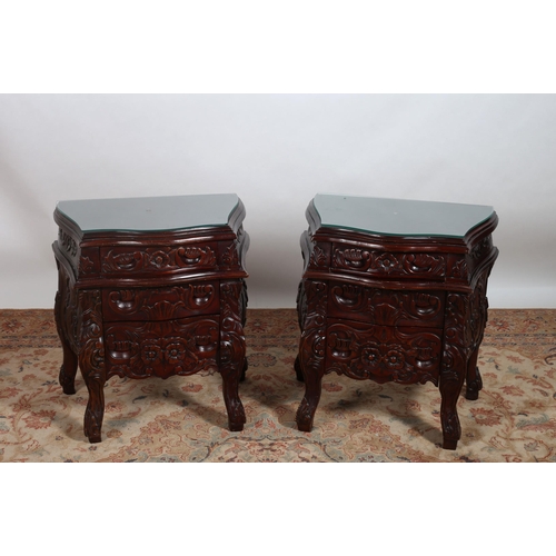 234 - A PAIR OF CONTINENTAL CARVED MAHOGANY CHESTS each of serpentine outline the shaped tops above three ... 