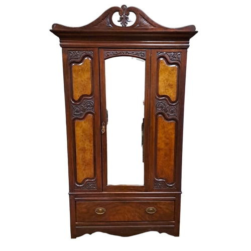 241 - AN EDWARDIAN CARVED MAHOGANY AND WALNUT WARDROBE the swan neck pediment above a bevelled glass centr... 