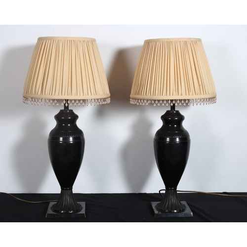 308 - A PAIR OF BRONZE URN SHAPED TABLE LAMPS with pleated shades raised on square bases 
73cm (h)