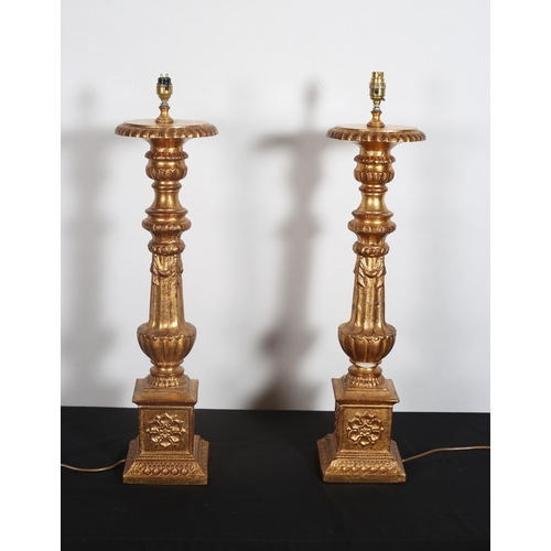 335 - A PAIR OF CONTINENTAL GILT TABLE LAMPS each with a fluted column hung with swags above a square base... 