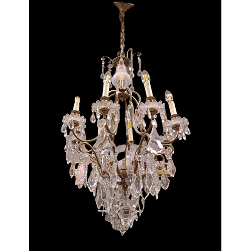 408 - A CONTINENTAL GILT BRASS AND CUT GLASS EIGHT BRANCH CHANDELIER hung with faceted pendants 
90cm drop