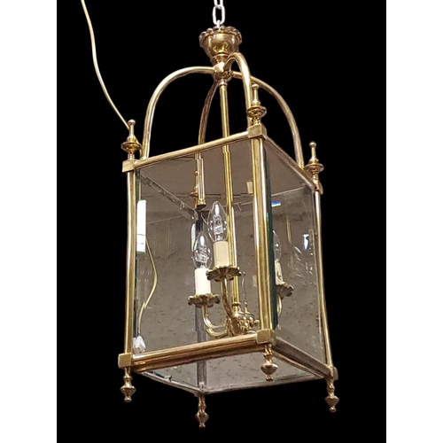 414 - A GOOD BRASS AND GLAZED THREE LIGHT LANTERN  of square form with bevelled glass panels the rectangul... 