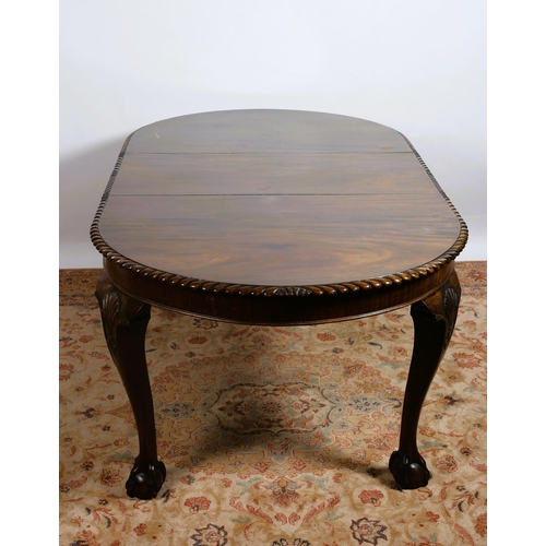 426 - A CHIPPENDALE STYLE MAHOGANY TELESCOPIC DINING TABLE of rectangular outline with rounded ends and ga... 