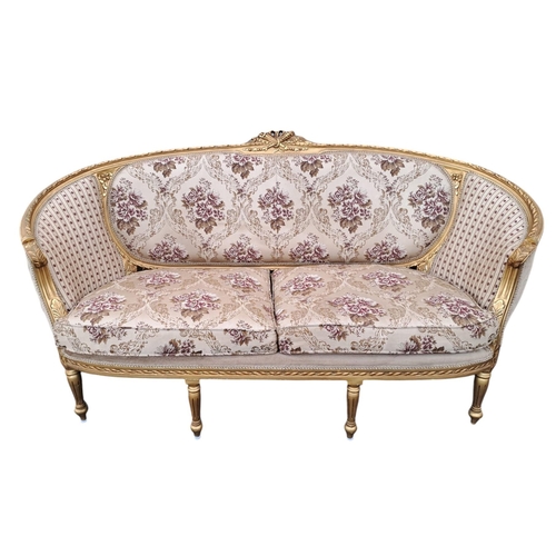 477 - A CONTINENTAL GILTWOOD AND UPHOLSTERED SETTEE the ribband frame with ribbon tied and flowerhead cres... 