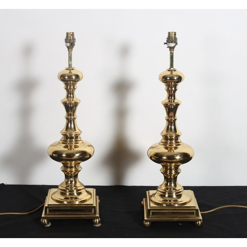 500 - A PAIR OF HEAVY BRASS TABLE LAMPS each with a baluster column raised on square platform with bun fee... 