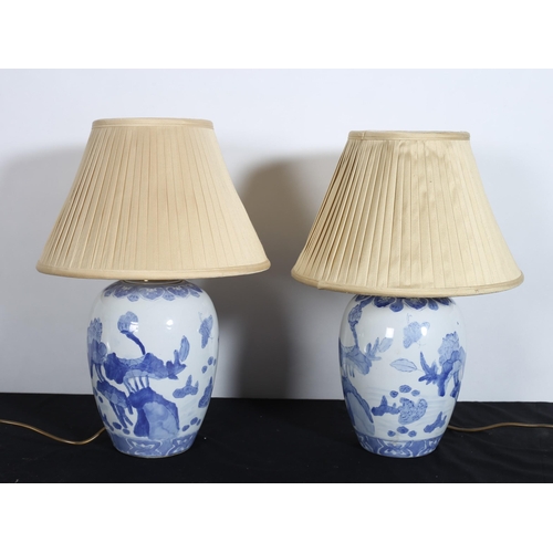 544 - A PAIR OF ORIENTAL BLUE AND WHITE TABLE LAMPS each of baluster form with pleated shades 
50cm (h)