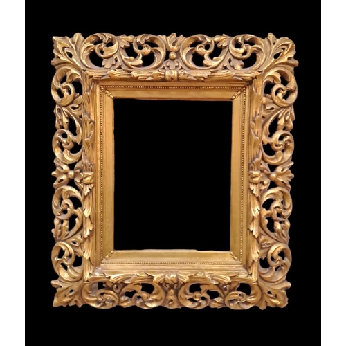 594 - A CONTINENTAL GILT FRAME MIRROR the rectangular bevelled glass plate within a pierced C-scroll and f... 